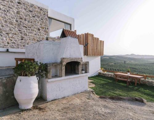 a building with a vase with a plant in it at Kambos Nature View Villa in Périon