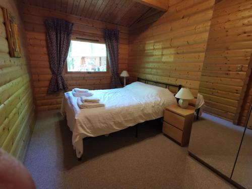 a bedroom with a bed in a log cabin at Fern Lodge in Louth