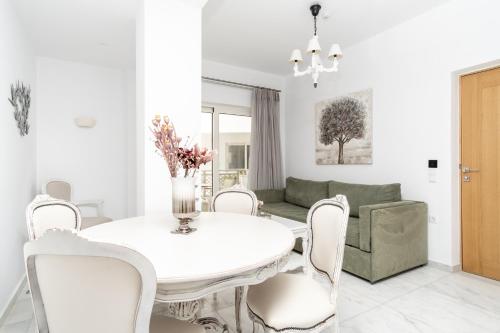 a white living room with a white table and chairs at Cyano Hotel in Plakias