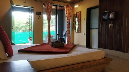 a large bed in a room with a large window at Bluebell Residency in Mahabaleshwar