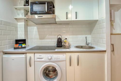 une petite cuisine avec une machine à laver et un évier dans l'établissement BEACH FLAT, à Nice