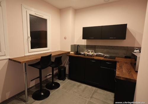 a kitchen with a desk with chairs and a television at Ds Plaisir Love Room avec sauna, jacuzzi à Nancy in Nancy