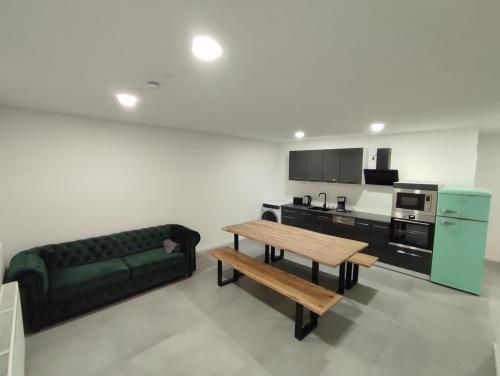a living room with a green couch and a table at Ferienwohnungen am Stadtgarten Pforzheim in Pforzheim