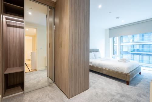 um quarto com uma cama e uma grande janela em Lovely 2 bed Condo London em Woolwich
