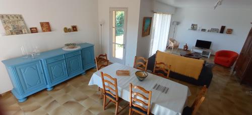 un salon avec une table et un meuble bleu dans l'établissement UNE CHOUETTE MAISON, à Beaucaire