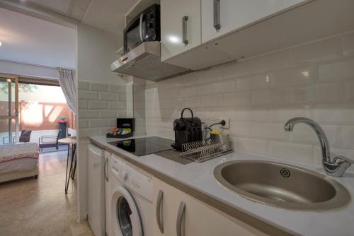 une cuisine avec un évier et un micro-ondes dans l'établissement BEACH FLAT, à Nice