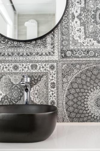 a bathroom with a black sink and a mirror at Cyano Hotel in Plakias