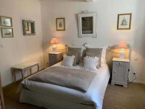 1 dormitorio con 1 cama blanca grande y 2 mesitas de noche en La Closeraie Saint Girons en Saint-Girons-dʼAiguevives