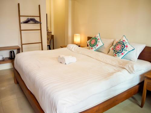 a bedroom with a large white bed with two towels on it at Baan Dan Ta Wan Nuea in Chiang Mai