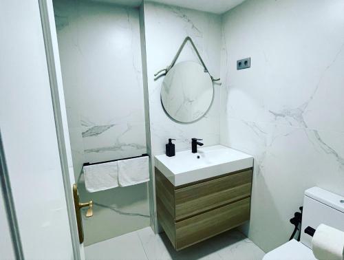 biała łazienka z umywalką i lustrem w obiekcie BALCON PLAYA Y PISCINA 2 Habitaciones IPANEMA PONDOS w Almuñécar