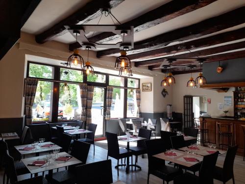 un restaurant avec des tables et des chaises dans une salle dans l'établissement Relais du Bois du Four, à Saint-Léons