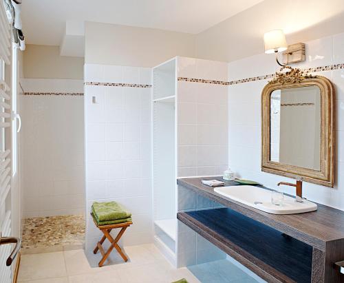 La salle de bains est pourvue d'un lavabo et d'un miroir. dans l'établissement Chambres d’hôtes la guirosse, à Sainte-Eulalie-en-Born