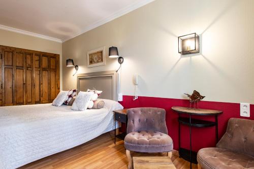 a bedroom with a white bed and a chair at Les Florets in Gigondas