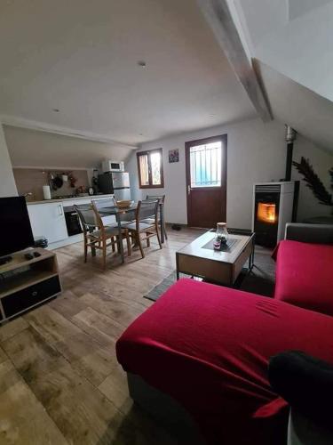 un salon avec un canapé rouge et une table dans l'établissement La Brise, à Saint-Maurice