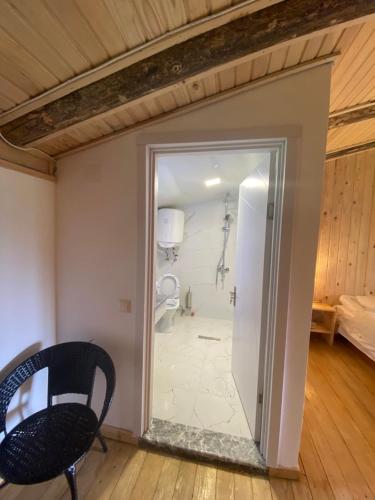 Cette chambre dispose d'une porte menant à une salle de bains pourvue de toilettes. dans l'établissement Hotel Chubezeni, à Mestia