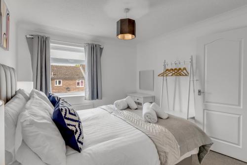 a bedroom with a white bed with pillows and a window at Guest Homes - Galley Lodge in Norwich
