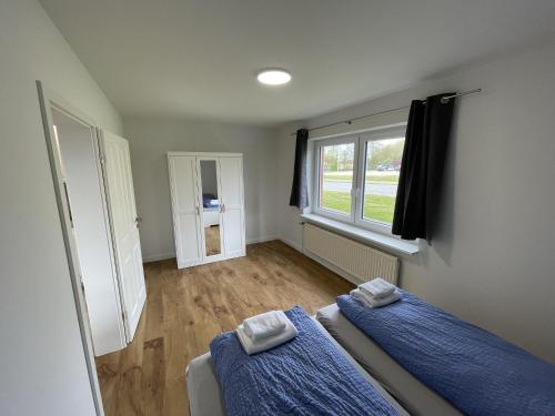 1 Schlafzimmer mit 2 Betten und einem Fenster in der Unterkunft Schleiblick App 14 in Rabenkirchen-Faulück