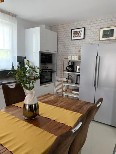 uma cozinha com uma mesa de madeira e um frigorífico em VillaGrey Tunari em Tunari