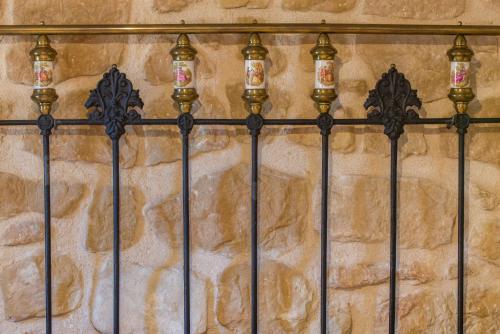 a wrought iron fence with lights on a stone wall at Cal Tomas, Ecoturisme Terra Alta in Bot