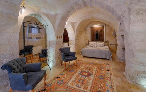 a bedroom with a bed and chairs in a room at Henna Hotel-Adults Only in Goreme
