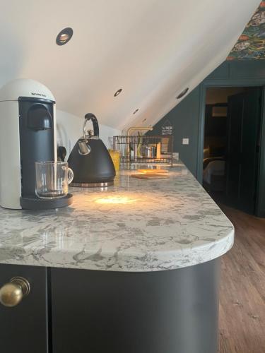 a kitchen with a counter with a coffee maker on it at Stylish one bedroom Cotswold Coach House Tetbury in Tetbury