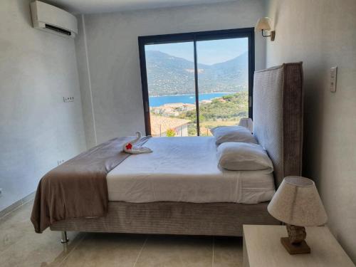 a bedroom with a bed with a large window at Appartement neuf 3 chambres vue mer Propriano in Propriano