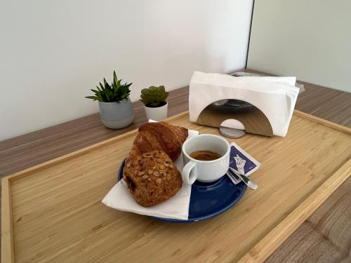 einen Teller Brot und eine Tasse Kaffee auf dem Tisch in der Unterkunft Oltremare rooms Agropoli in Agropoli