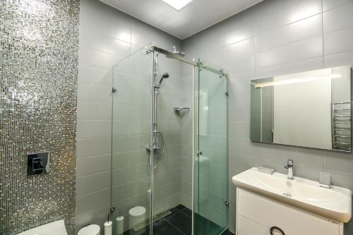 La salle de bains est pourvue d'une douche en verre et d'un lavabo. dans l'établissement VIP APARTAMENT NIZAMI STREET, à Baku