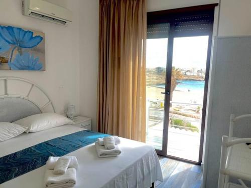 a hotel room with a bed, table and window at Mir Mar in Lampedusa