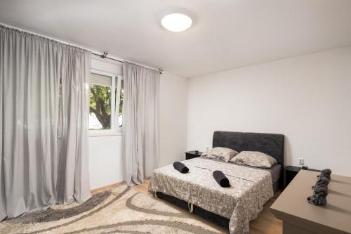 ein weißes Schlafzimmer mit einem Bett und einem Fenster in der Unterkunft Wild in Sinj