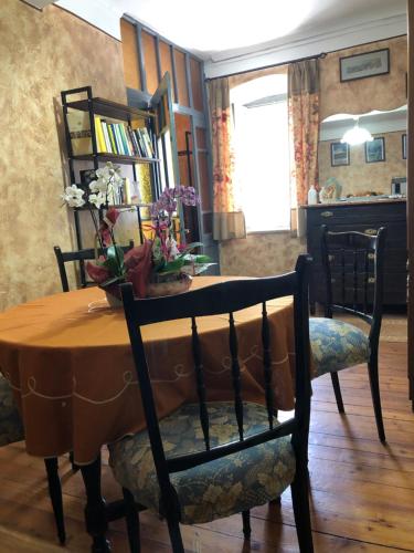 a table with two chairs and a table with flowers on it at L'orologio panoramico in Luserna San Giovanni