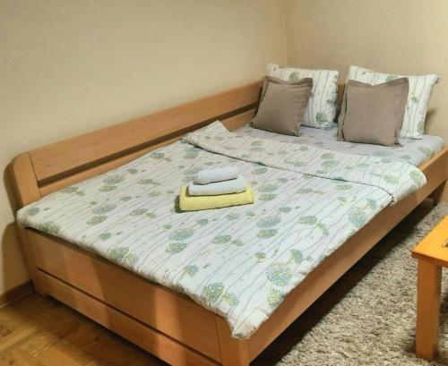 a bed with a wooden headboard with a blanket on it at Tara Apartmani Malešević - 2 in Bajina Bašta