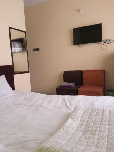 1 dormitorio con cama, sofá y TV de pantalla plana en Hotel GM Palace en Chittagong