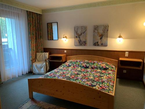 ein Schlafzimmer mit einem Bett mit einer farbenfrohen Tagesdecke in der Unterkunft Ski und Therme 2 in Bad Kleinkirchheim