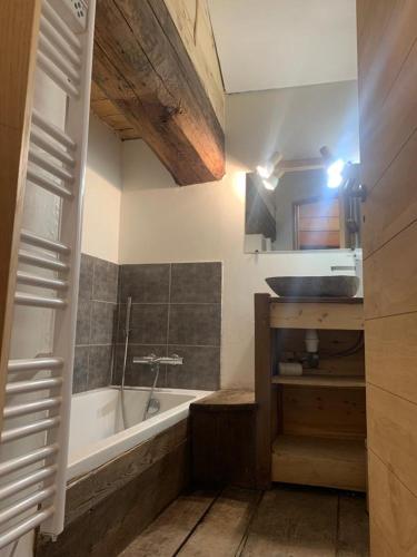 une salle de bain avec une baignoire et un lavabo dans l'établissement La ferme du Savetier, à Sangot