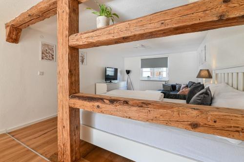 a bedroom with a large bed with wooden beams at FEWO Im alten Fachwerkhaus in Bad Buchau