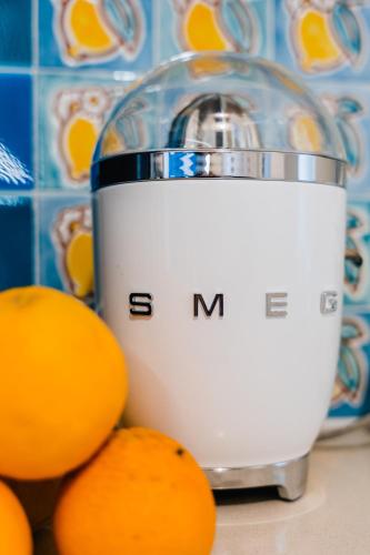 a juicer sitting on a counter next to oranges at Lemon in the air Family in Pontone