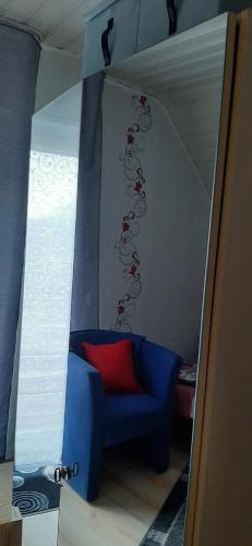 a room with a blue chair with a red pillow at Ferienwohnung Gutowski in Andernach