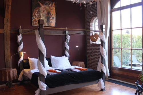 a bedroom with a bed with a hanging bed frame at Boutique Hotel Nieuw Beusink in Winterswijk