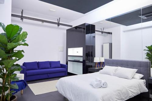 Un dormitorio con una cama grande y un sofá azul. en LOFT PRINCIPE PIO, en Madrid