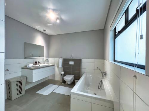 Un baño con bañera, lavabo e inodoro. en Turmalin Cottage Unit 2, en Swakopmund