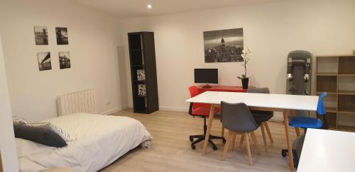 a bedroom with a bed and a desk and a bed and a table at Adorable studio 25m² très calme avec parking in Marseille
