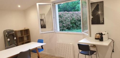 a room with a table and chairs and a window at Adorable studio 25m² très calme avec parking in Marseille