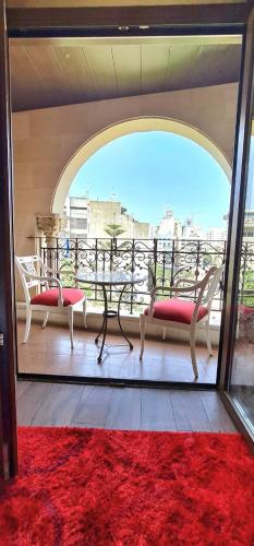 a balcony with two chairs and a table and a red rug at Q Hotel in Beirut