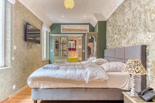 a bedroom with a large bed and a mirror at Ryad Mogador Liège in Liège