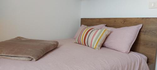 a bed with four pillows on top of it at Bitini Farm Apartment in Gračišče