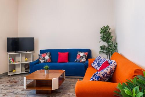 sala de estar con sofá azul y sillas de color naranja en Gardappartamenti Rivo lake view, en Desenzano del Garda