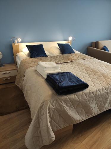 ein großes Bett mit zwei Kissen darüber in der Unterkunft Blue Sky - apartament z pięknym widokiem na górę Telegraf in Kielce