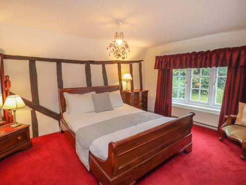 1 dormitorio con 1 cama grande y alfombra roja en Shepherd Cottages luxury self catering in heart of Kent, en Lenham