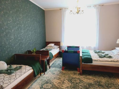 a bedroom with two beds and a window at Blanka Villa Wellness Home in Bakonyszentlászló